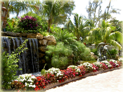 outdoor landscaping wall with waterfall and flower beds in front